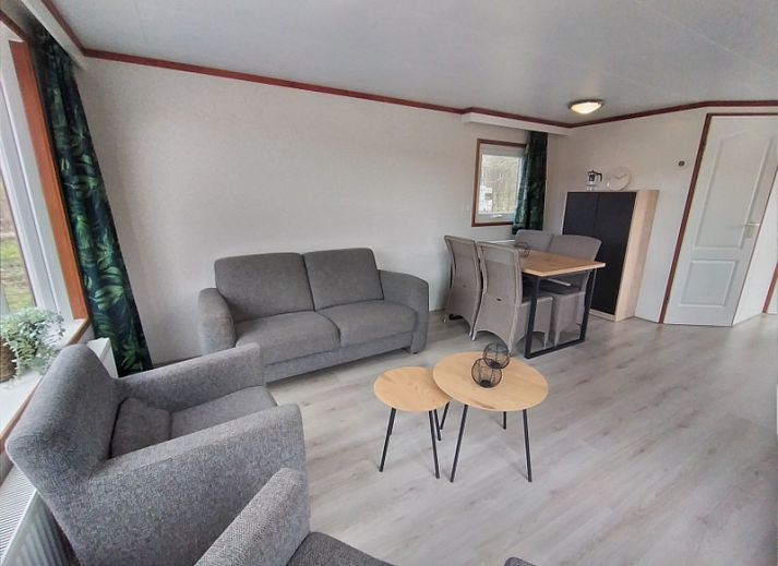 Veranda of Chalet Out and Home in De Koog, Texel, with wooden fence and parasol.