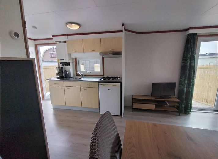 Veranda of Chalet Out and Home in De Koog, Texel, with wooden fence and parasol.