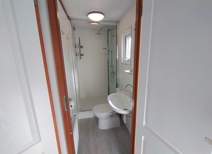 Cozy living room in Chalet Uit en Thuis, De Koog, Texel, with comfortable chairs and views of the terrace.