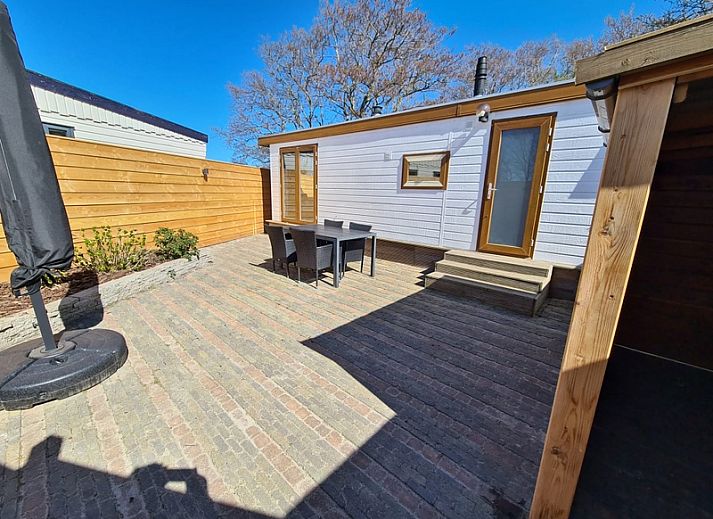 Spacious living space in Chalet Uit en Thuis, De Koog, Texel, with sitting area and dining table.