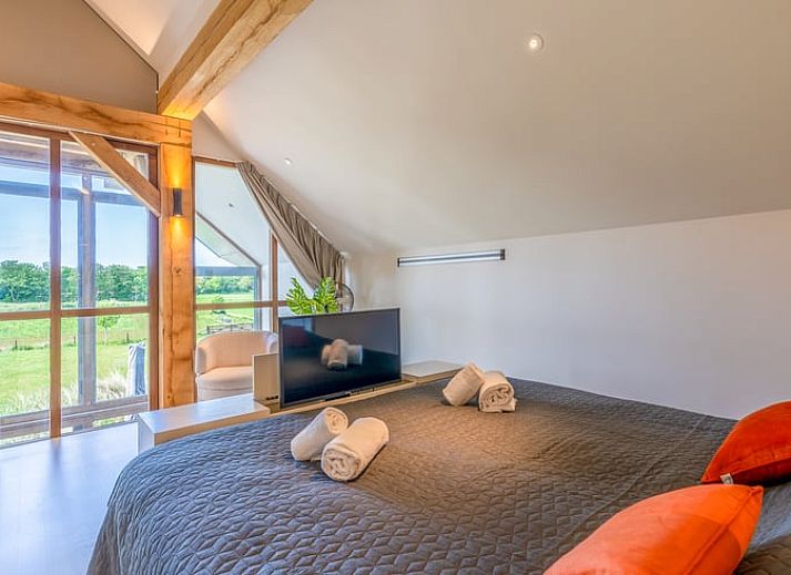 Open living room in Holiday Home in De Koog with comfortable sitting area and bookshelves.