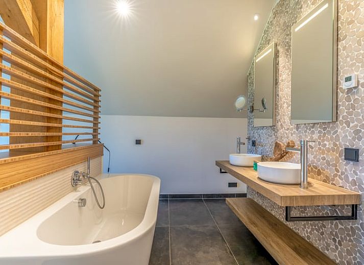 Open living room in Holiday Home in De Koog with comfortable sitting area and bookshelves.