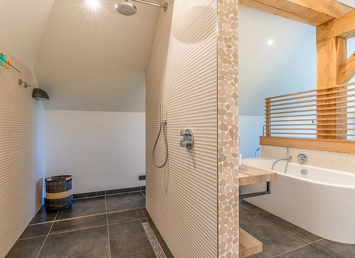 Open living room in Holiday Home in De Koog with comfortable sitting area and bookshelves.