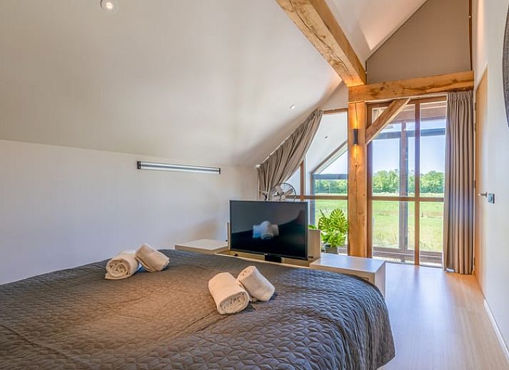 Open living room in Holiday Home in De Koog with comfortable sitting area and bookshelves.