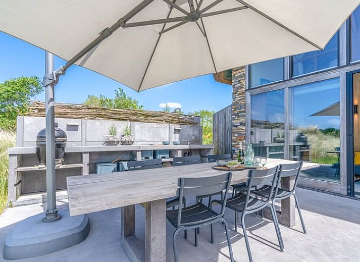 Wooden fireplace in cottage in De Koog overlooking terrace and nature.