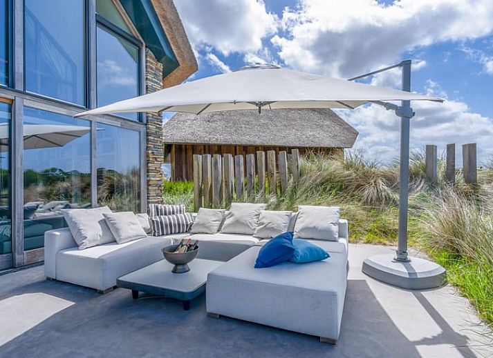 Wooden fireplace in cottage in De Koog overlooking terrace and nature.