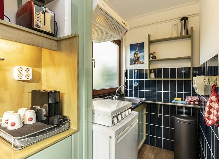Entrance to vacation home Schanulleke in De Koog, Texel, with green plants and an inviting entrance.
