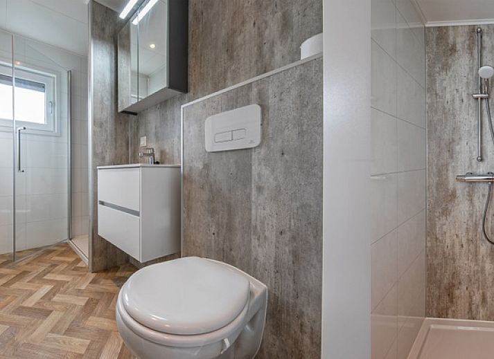 Dining area in Chalet Park Bregkoog - Chalet Bregkoog 162, Texel with wooden table and comfortable chairs for cozy meals.