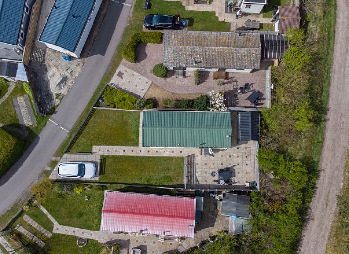 Front view of Chalet Bregkoog 205, a vacation home in De Koog Texel with green surroundings.