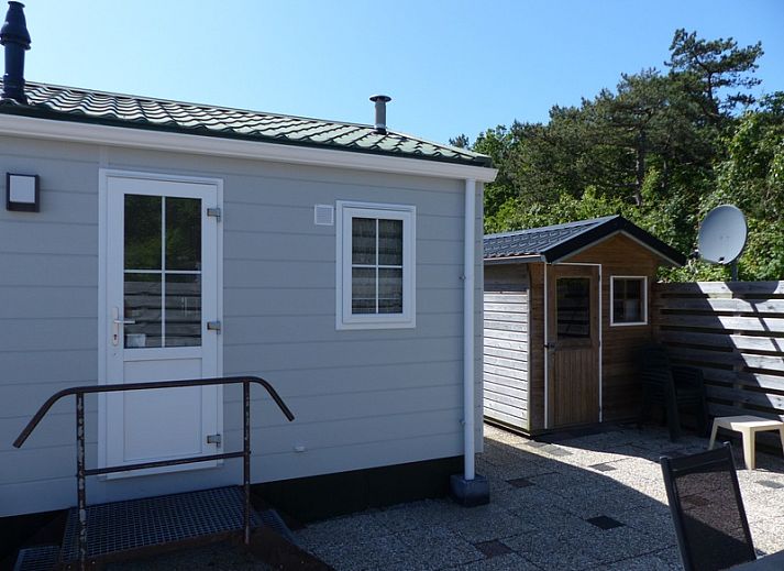 Front view of Chalet Bregkoog 205, a vacation home in De Koog Texel with green surroundings.