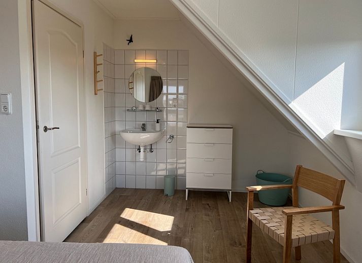 Vogelweelde vacation accommodation in De Koog, Texel with sunny garden and wooden fence.