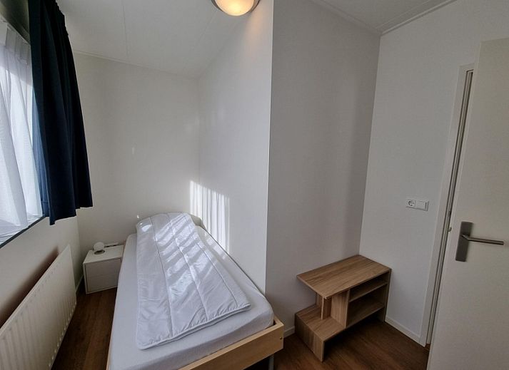 Cozy sitting room in Bungalow Epelaan 13, De Koog, Texel, with sitting area and large windows for lots of natural light.