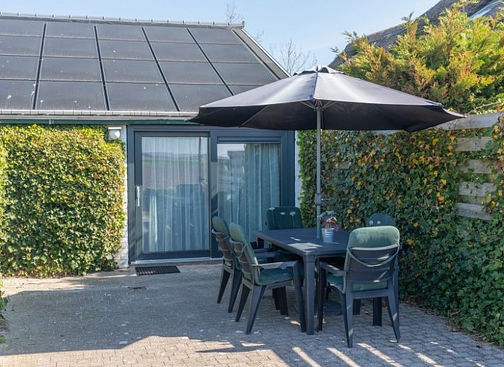 Gemuetliches Wohnzimmer im Bungalow 1, De Koog, Texel mit stilvollen Moebeln und viel Tageslicht.