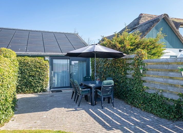 Gemuetliches Wohnzimmer im Bungalow 1, De Koog, Texel mit stilvollen Moebeln und viel Tageslicht.