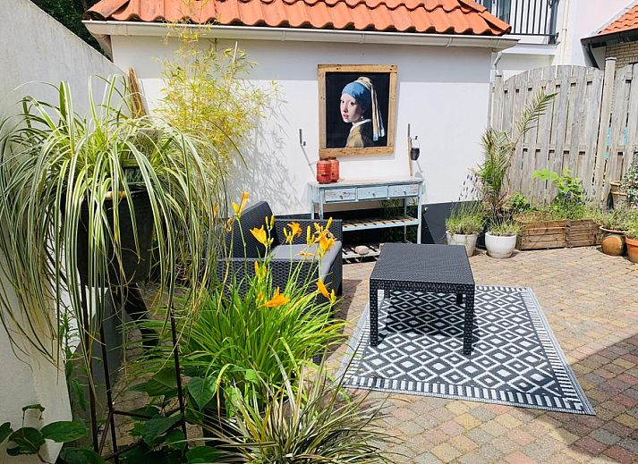 Gemuetlicher Innenhof im Ferienhaus Texel D in De Koog, Texel, mit bunten Blumen und bequemen Sitzgelegenheiten.