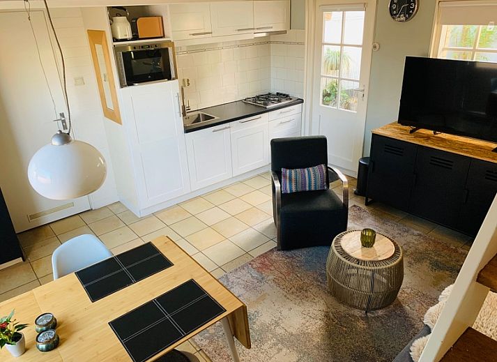 Gemuetlicher Innenhof im Ferienhaus Texel D in De Koog, Texel, mit bunten Blumen und bequemen Sitzgelegenheiten.