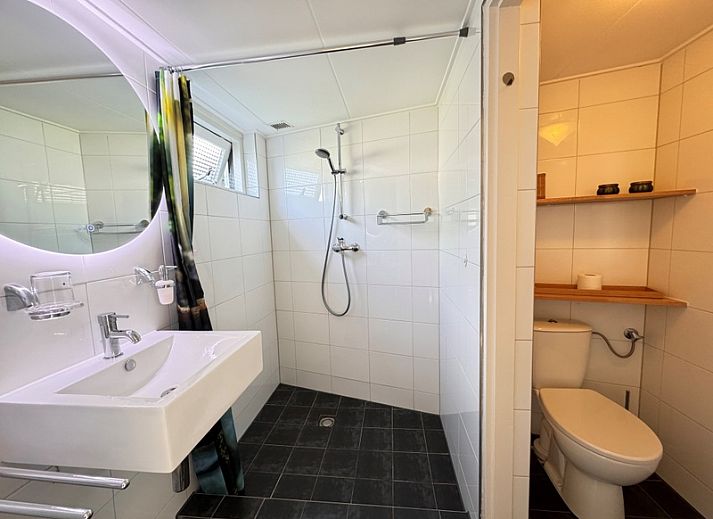 Gemuetlicher Innenhof im Ferienhaus Texel D in De Koog, Texel, mit bunten Blumen und bequemen Sitzgelegenheiten.