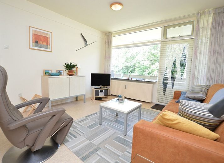Gemuetliches Wohnzimmer im Appartement Kerckeland 64, De Koog, Texel mit bequemer Sitzecke und viel Licht.