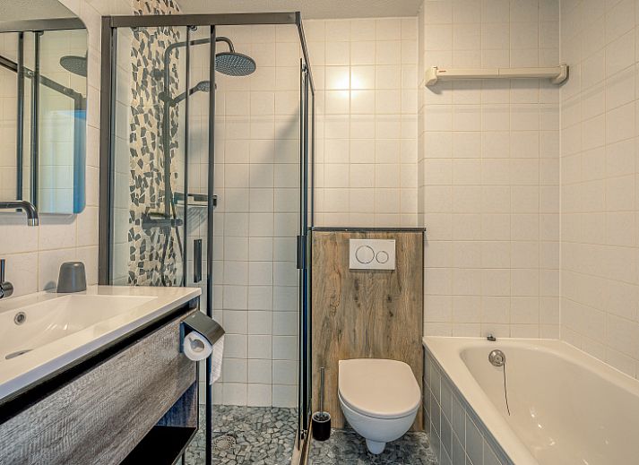 Stijlvolle zitruimte van Appartement Zeedistel 20 in De Koog, Texel met flatscreen-tv en sfeervolle decoraties.