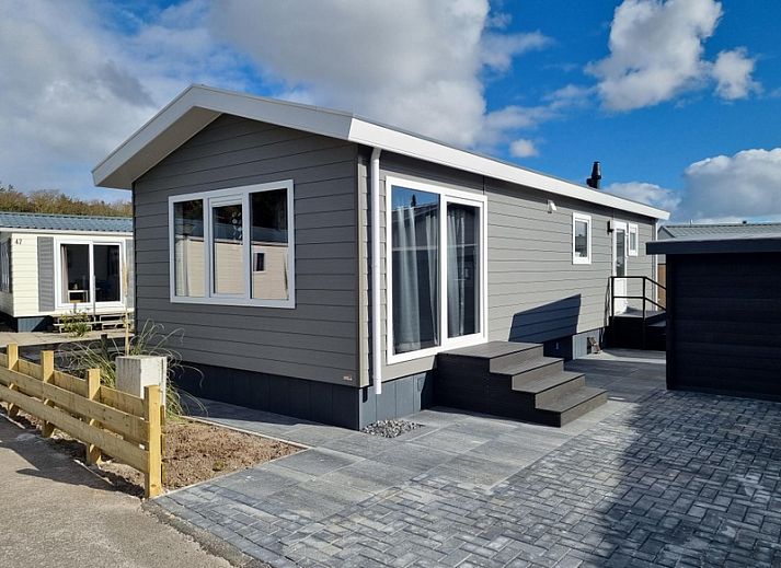 Chaletpark Bregkoog - Chalet 45 TX45 in De Koog, Texel, modernes Aeusseres mit Veranda und blauem Himmel.