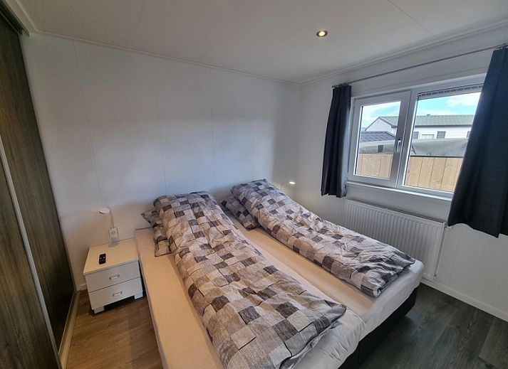 Chaletpark Bregkoog - Chalet 45 TX45 in De Koog, Texel, Ferienhaus mit grauer Fassade und grossem Innenhof.