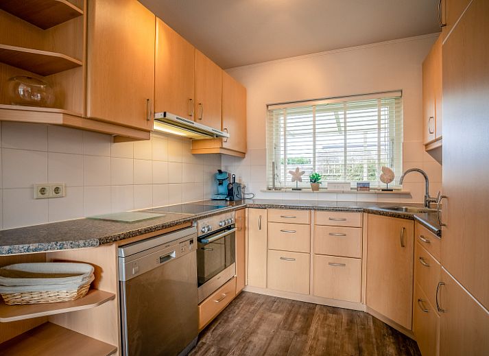 Spacious living room of Orchismient 2, vacation home in De Koog, Texel with comfortable sofa and dining area.