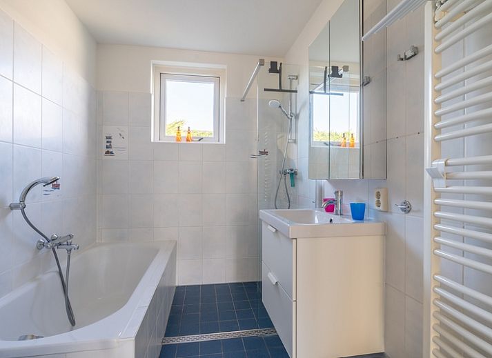 Cozy sitting area in Orchismient 2, vacation home Texel, with large sofa and wooden coffee table.