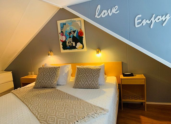 Cozy living room in vacation home Texel A, De Koog, with comfortable seating area and garden view.