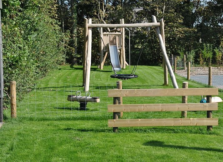 Aussenterrasse von Tapuit 10a, Ferienhaus in De Koog, Texel mit Gartentisch und Stuehlen.