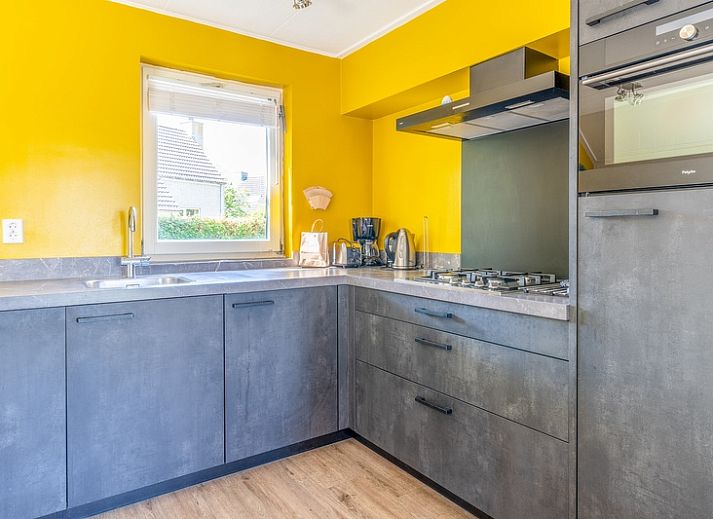 View of Holiday home Honeysuckle 71 in De Koog, Texel with green surroundings.