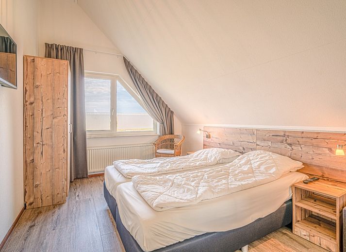 View of Holiday home Honeysuckle 71 in De Koog, Texel with green surroundings.