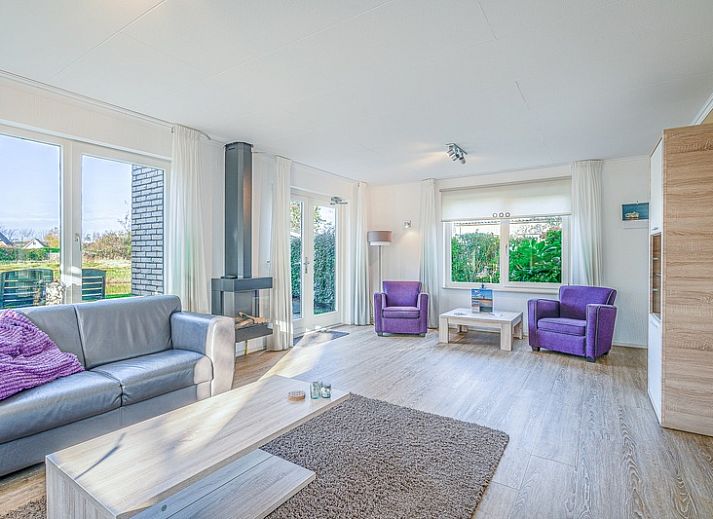 Sunny terrace of Holiday home Honeysuckle 59 in De Koog Texel, with comfortable seating and green surroundings.