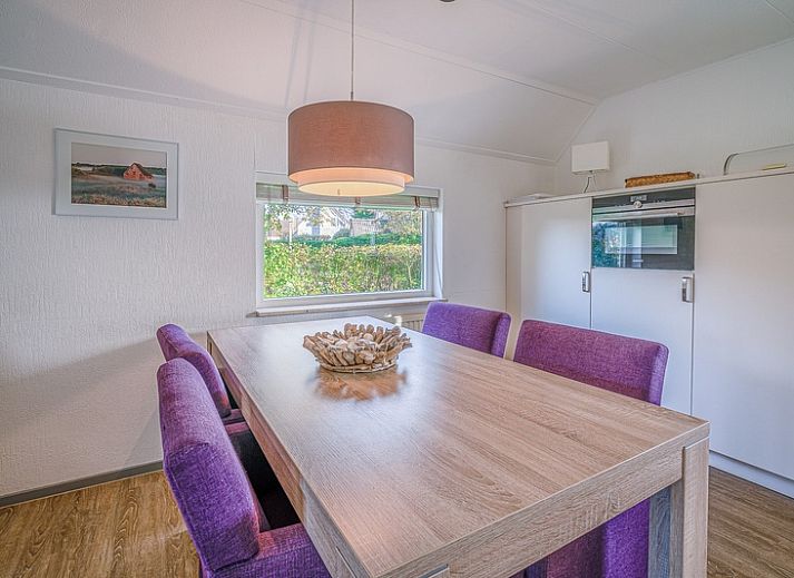 Sunny terrace of Holiday home Honeysuckle 59 in De Koog Texel, with comfortable seating and green surroundings.