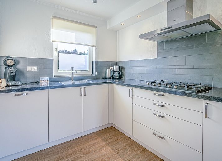 Sunny terrace of Holiday home Honeysuckle 59 in De Koog Texel, with comfortable seating and green surroundings.