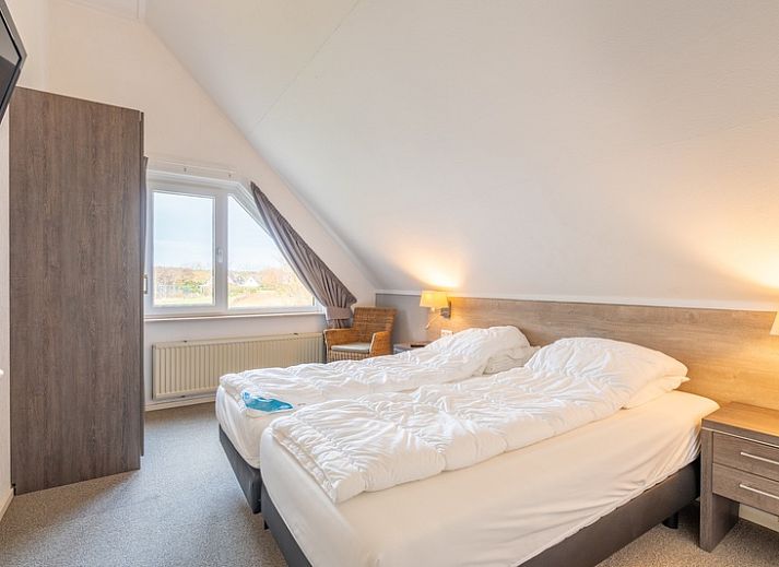 Sunny terrace of Holiday home Honeysuckle 59 in De Koog Texel, with comfortable seating and green surroundings.