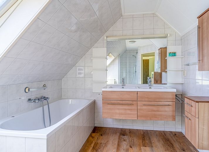 Cozy living room of Holiday home Kamperfoelie 59 in De Koog Texel, with modern sofas and lots of natural light.