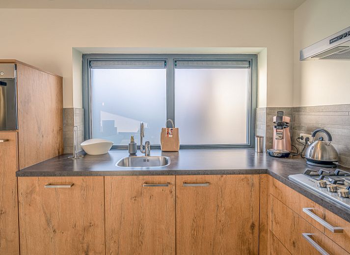 Cozy living room in vacation home Het Bospad - Brink 15, De Koog, Texel. Comfortable sofa and lots of natural light.