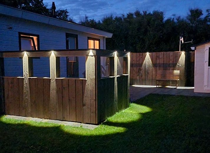 Essecke im Chalet Bregkoog 213 auf Texel, Chaletpark Bregkoog, mit Holztisch und modernen Stuehlen.