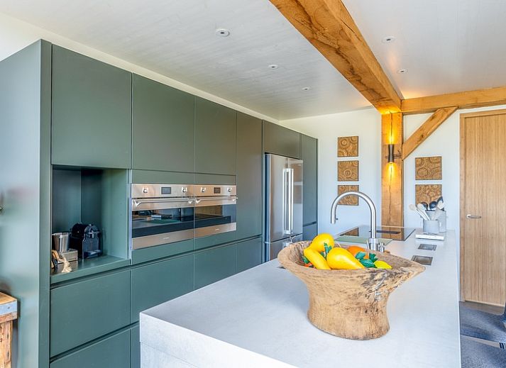 Cozy living room in Villa 193, De Koog, Texel, with fireplace and views of the natural surroundings.