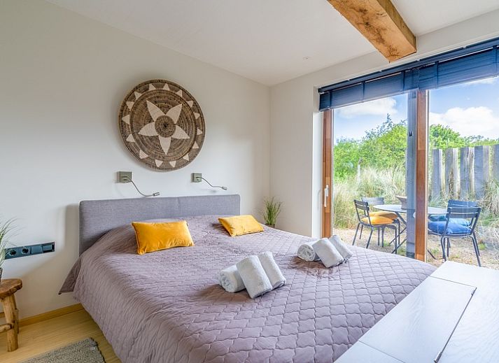 Open kitchen and sitting area in Villa 193, vacation home in De Koog, Texel, with wooden beams and modern furnishings.