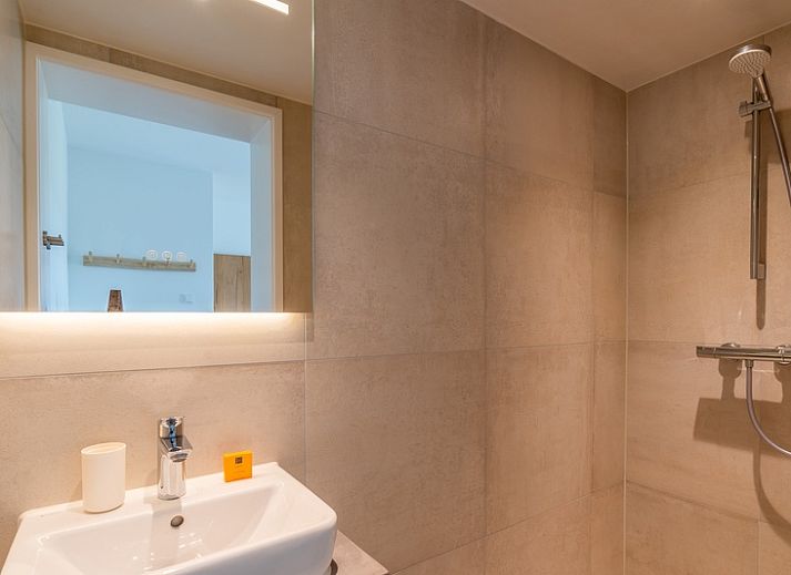 Cozy living room of Orchismient 17 in De Koog Texel with comfortable seating area and views of nature.