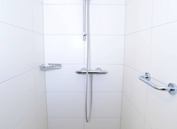 Modern kitchen in vacation home 32b Pollux, De Koog, Texel with dining area and bright red accents.