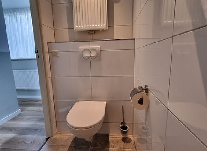 Bedroom in Bungalow 5100, Texel, with double bed and painting.