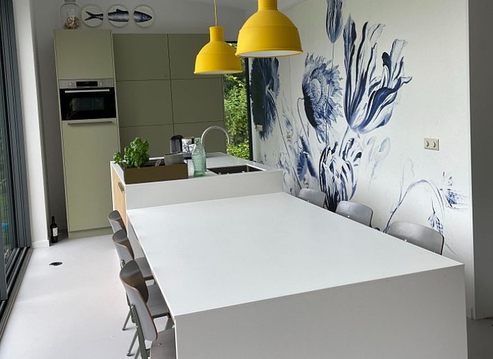 Modern dining room in De Koerie vacation home De Koog Texel with stylish decor and views of nature.