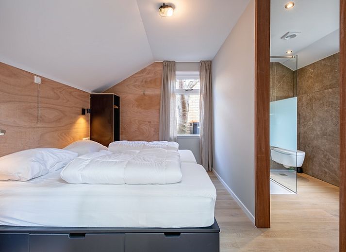 Gemuetlicher Innenbereich des Ferienhauses Pippa, De Koog, Texel, mit bequemem Sofa und Essecke.