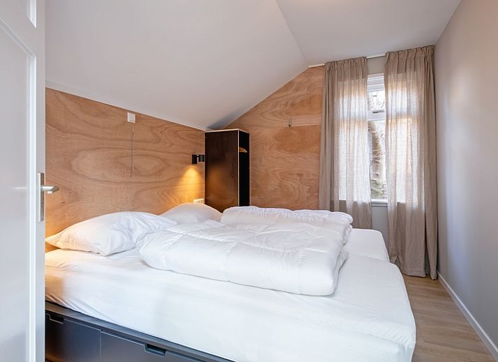 Gemuetlicher Innenbereich des Ferienhauses Pippa, De Koog, Texel, mit bequemem Sofa und Essecke.