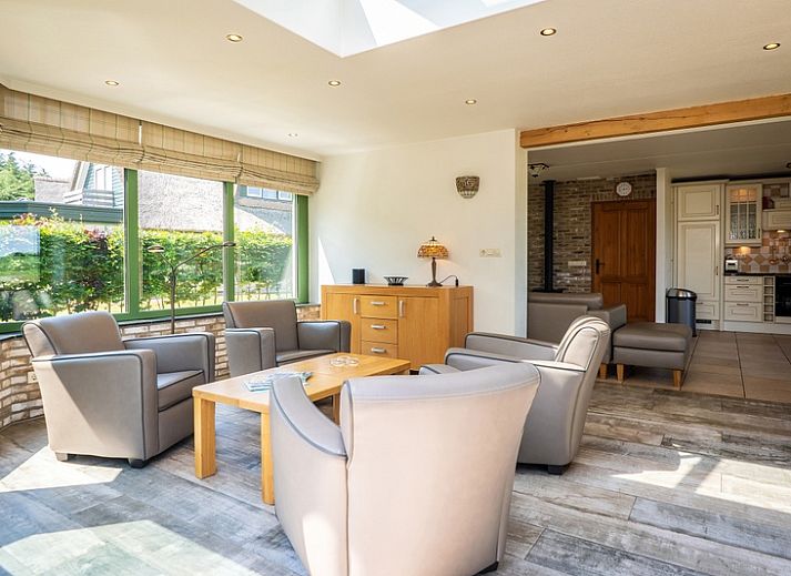 Gemuetliches Wohnzimmer der Villa mit Wintergarten in De Koog, Texel, mit Kamin und gemuetlicher Sitzecke.