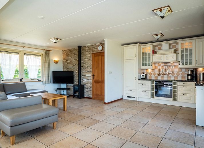 Gemuetliches Wohnzimmer der Villa mit Wintergarten in De Koog, Texel, mit Kamin und gemuetlicher Sitzecke.