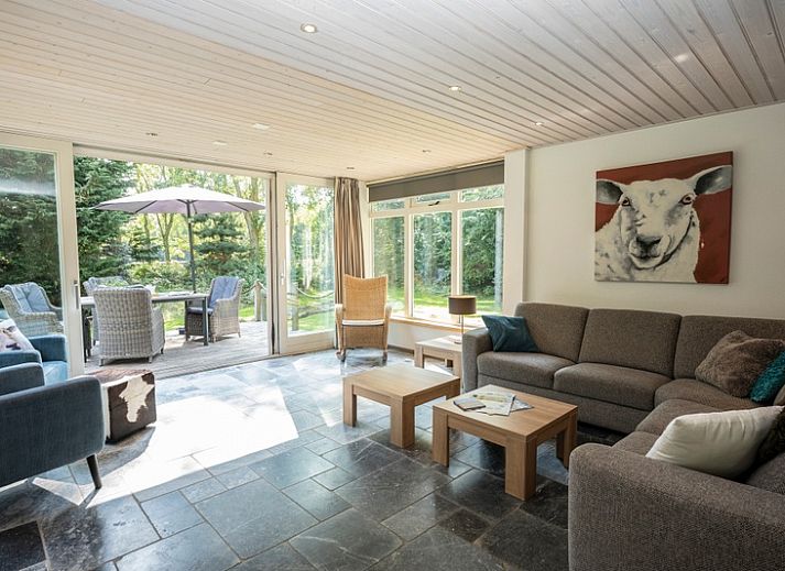 Vacation home Westenwind in De Koog, Texel with thatched roof and terrace among green trees.