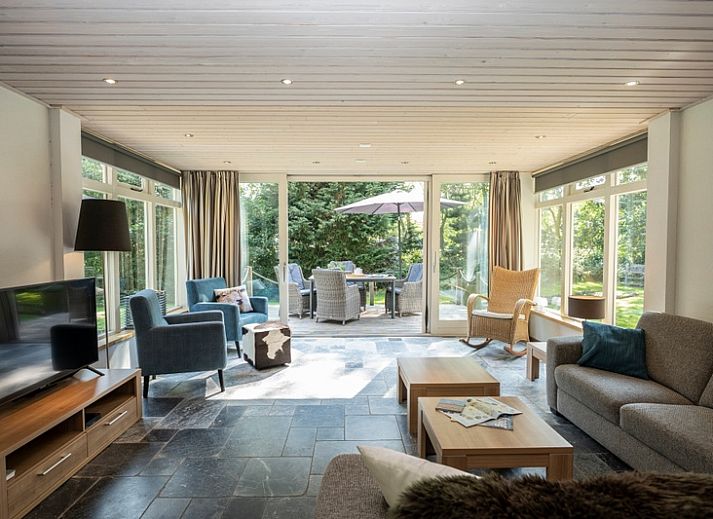 Vacation home Westenwind in De Koog, Texel with thatched roof and terrace among green trees.